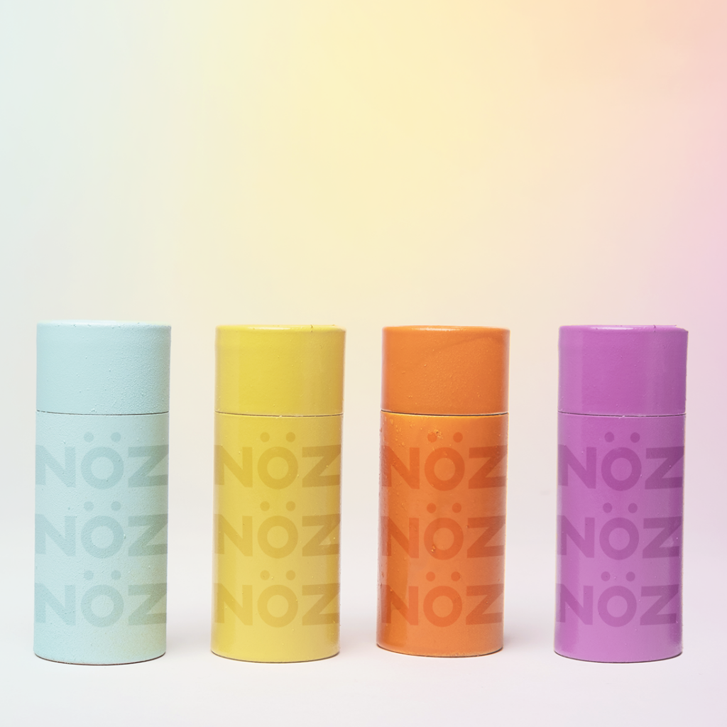 Nöz Sunscreen neon colors sky blue, dandelion, marmalade, and violet organized in that order next to each other.
